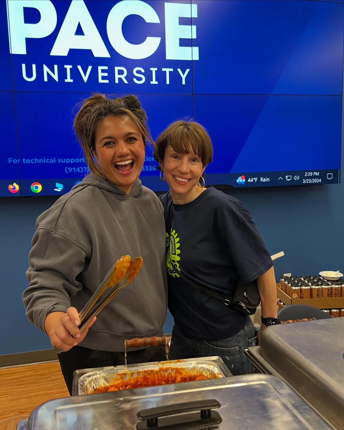 Two volunteers serving food at the tasting at Pace University