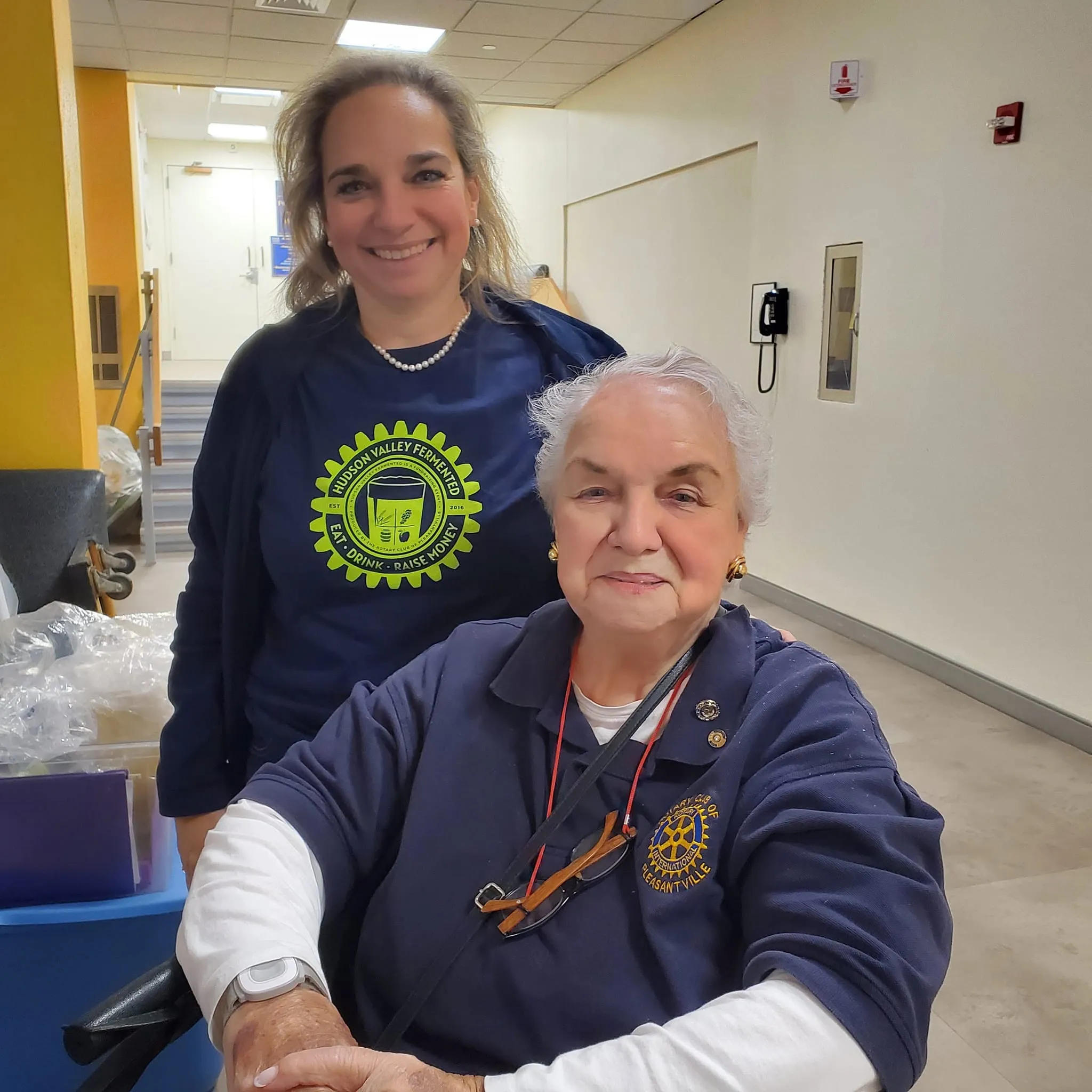 Helen Grishman seated with a volunteer in a Hudson Valley Fermented shirt