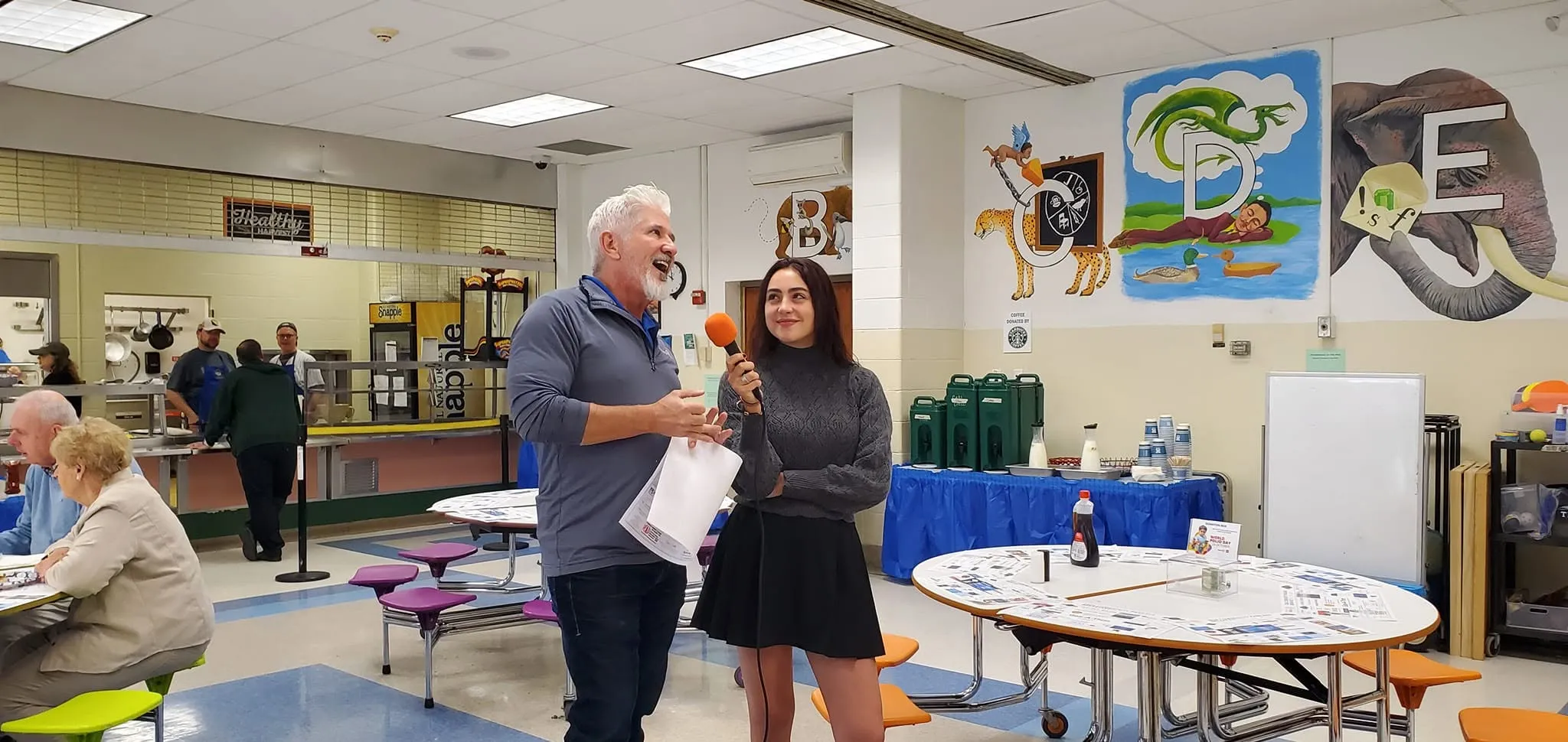 A member being interviewed for local TV in the school cafeteria at the Pancake Breakfast