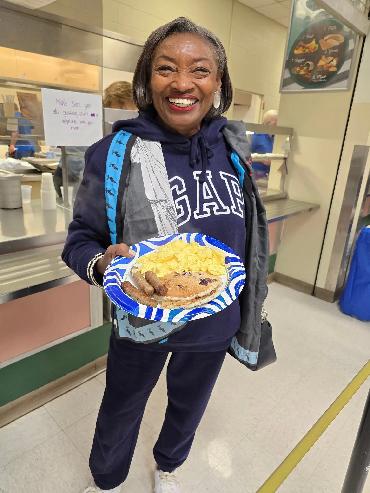 Senate Majority Leader Andrea Stewart-Cousins holding a plate of pancakes, eggs and sausage in the school cafeteria